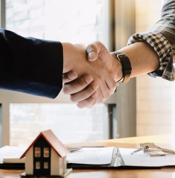 Real estate agent and customers shaking hands together celebrating finished contract after about home insurance and investment loan, handshake and successful deal.
